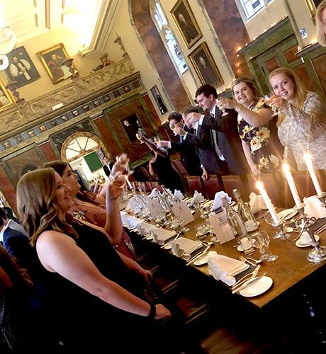 St. 博纳旺蒂尔大学 students raise their glasses in a toast at Oxford
